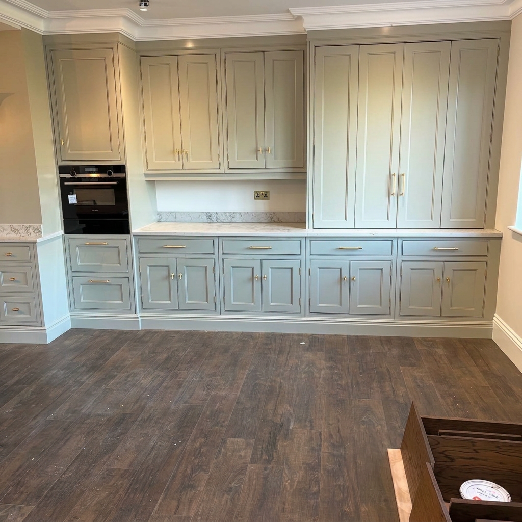 Kitchen cabinets after professional sage green respray with brass handles